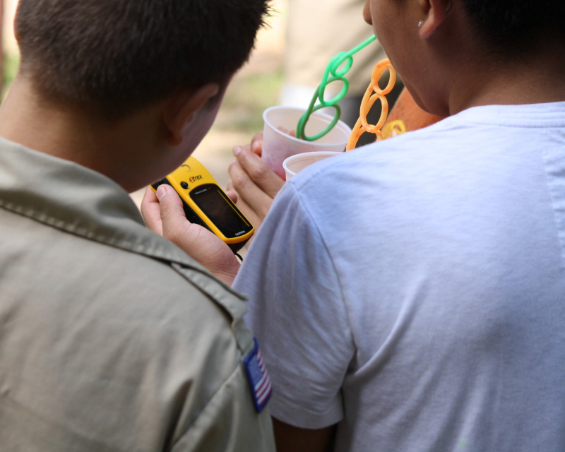 Three Scouts looking at a handheld GPS unit