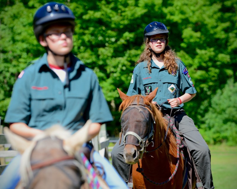 Two venturing Scouts in uniform riding horses